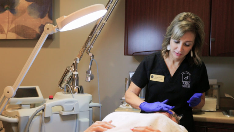 woman preparing patient's face for Laser Scar Removal Dallas