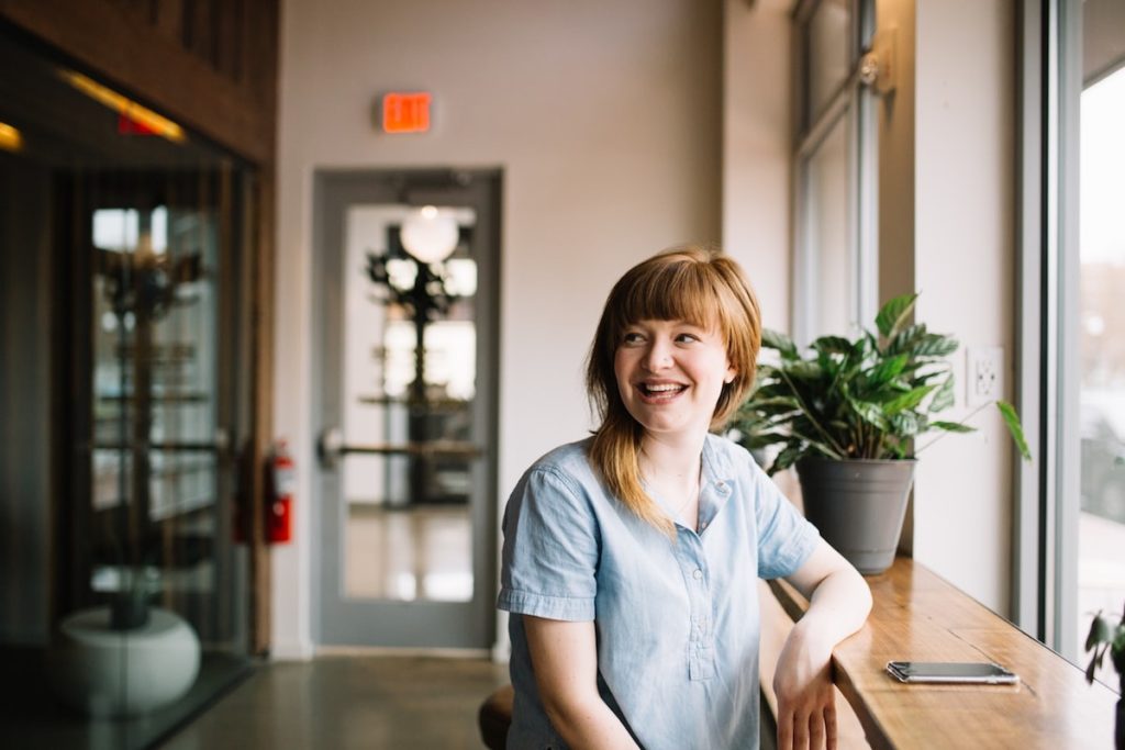 red haired woman smiling in a coffee shop