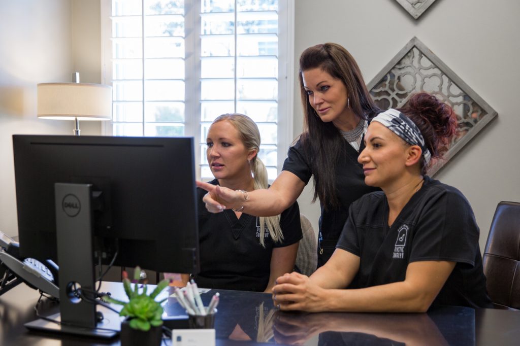 med spa staff working together on a computer to schedule a age spot removal laser treatment in Dallas