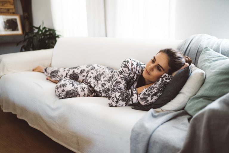 woman in pajamas relaxing on the couch