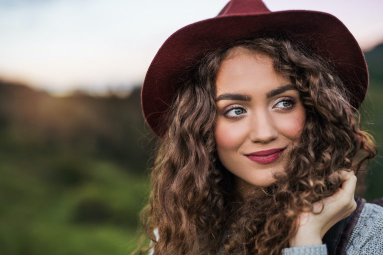 portrait of a beautiful woman in a rede hat outside