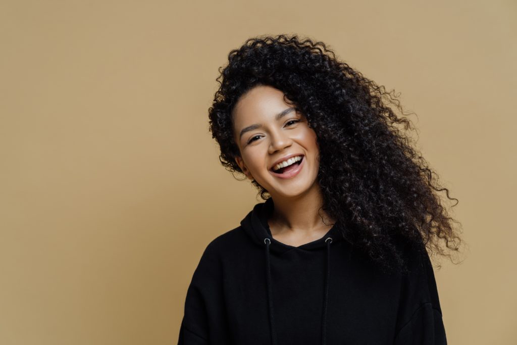 beaitful young woman with curly hair laughing