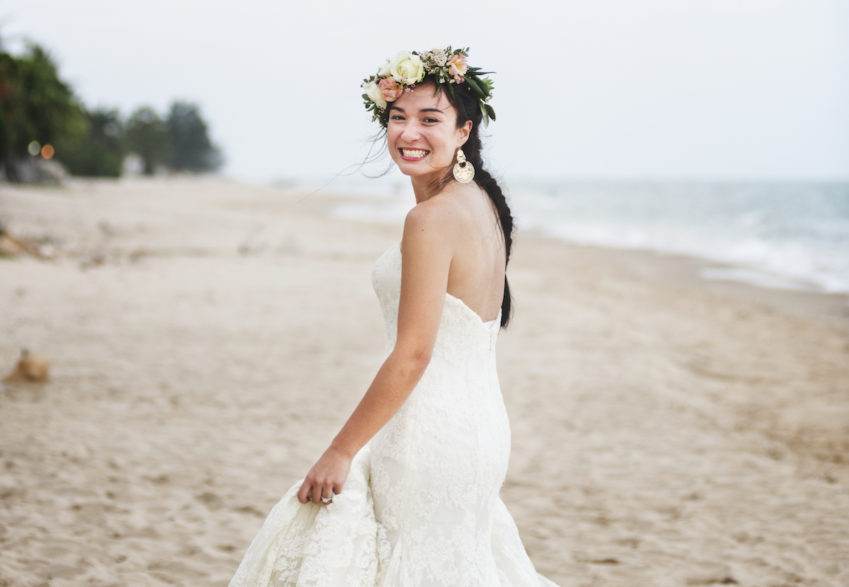 smiling bride with floral crown on the beach
