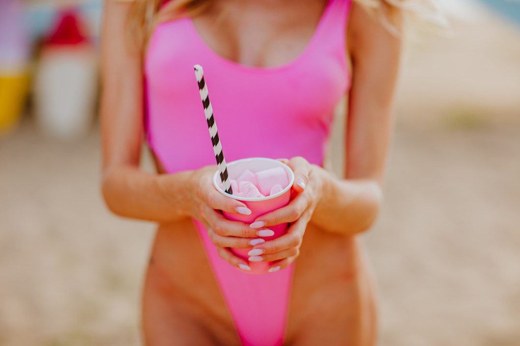 woman in pink swimsuit holding a pink cup of marshmallows