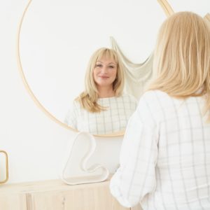 A woman admires herself after a treatment for CoolSculpting in Dallas