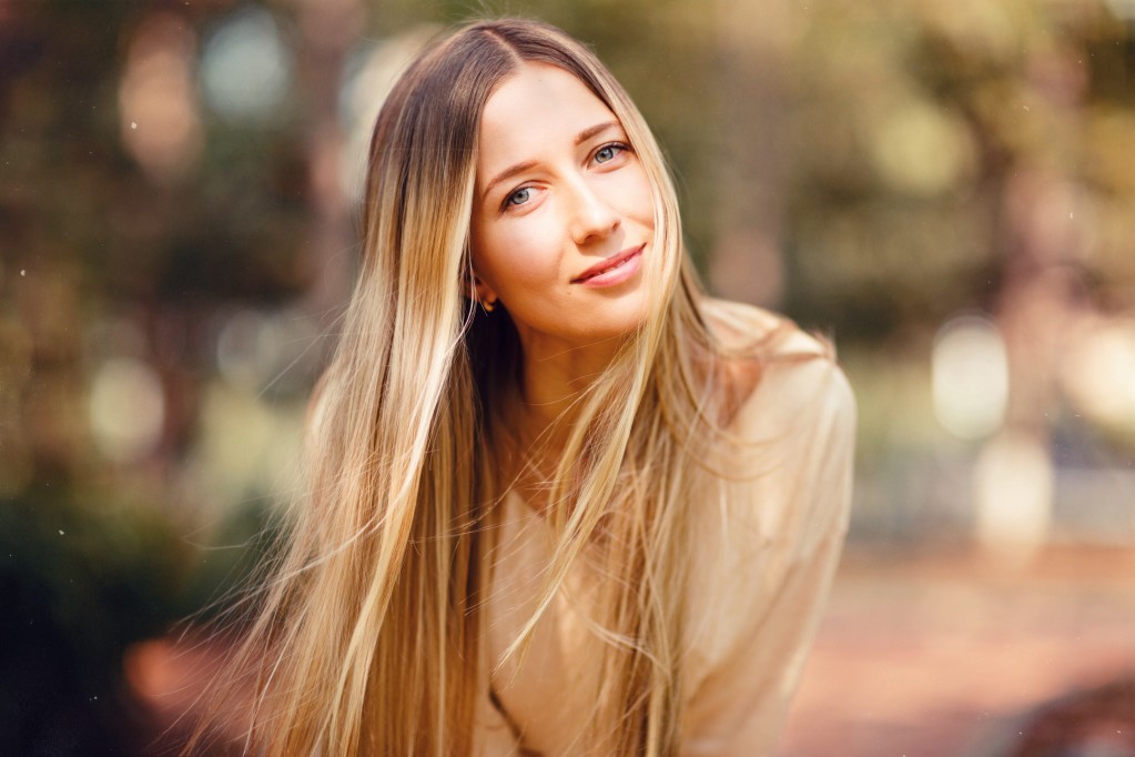 protrait of a smiling woman with long blonde hair outside