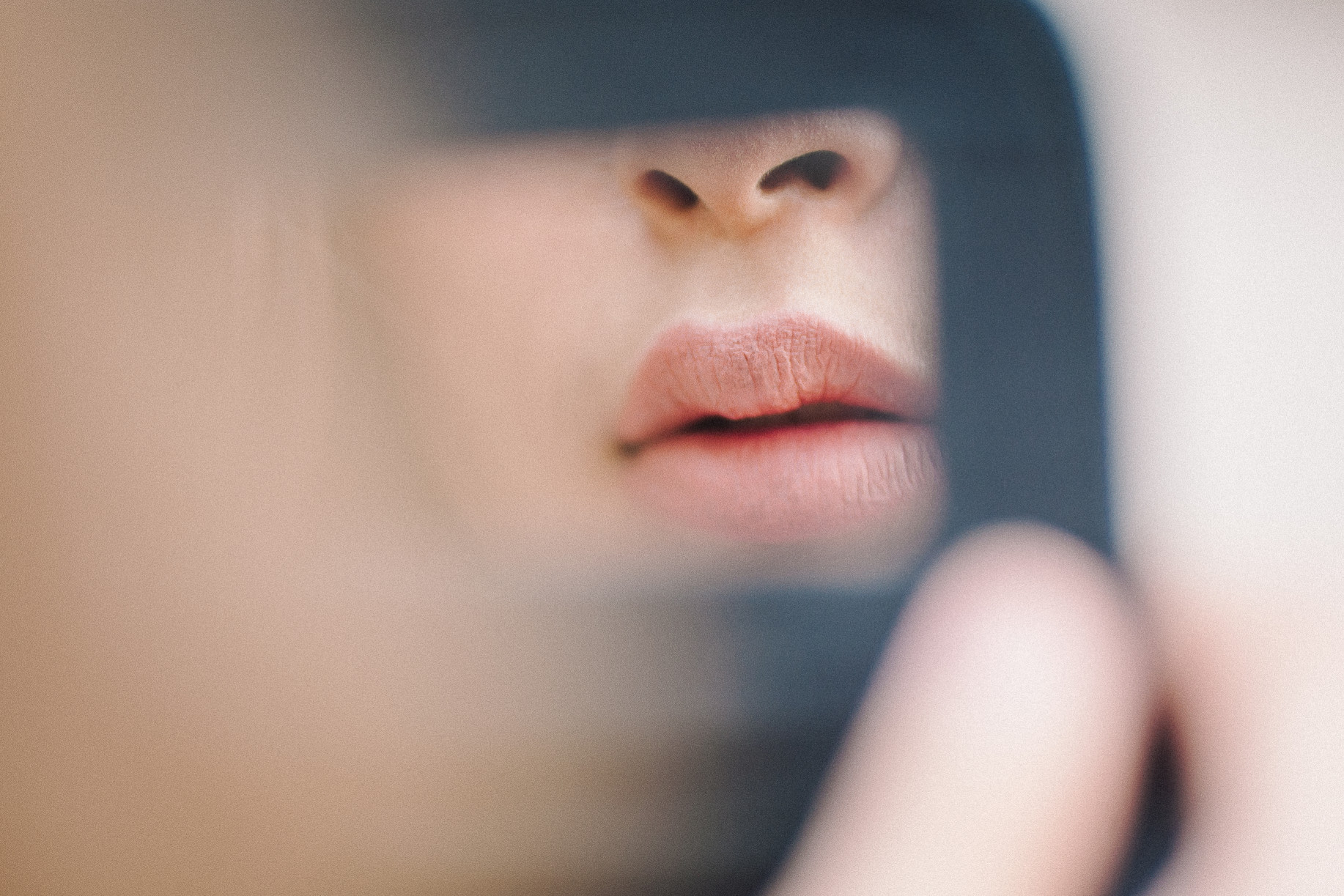 woman looking at plump lips in compact mirror