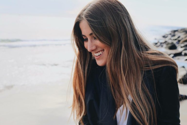 portrait of a smiling brunette woman at the beach