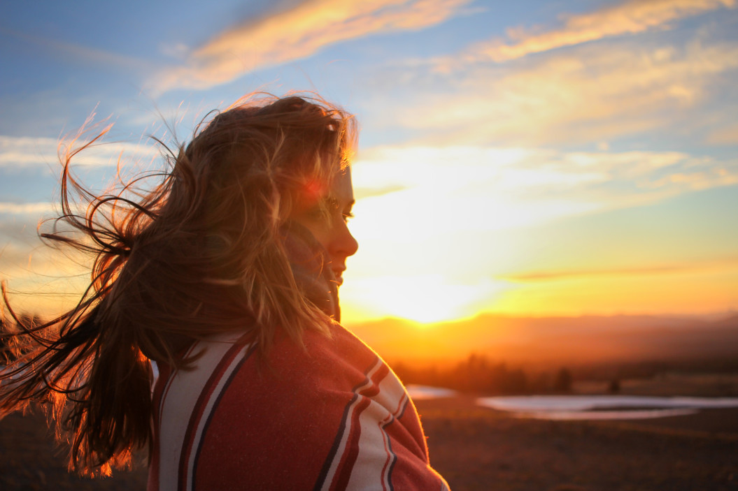 woman's hair blowing in front of the sunset
