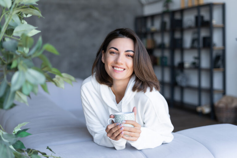 woman laying on bed smiling because of facelift