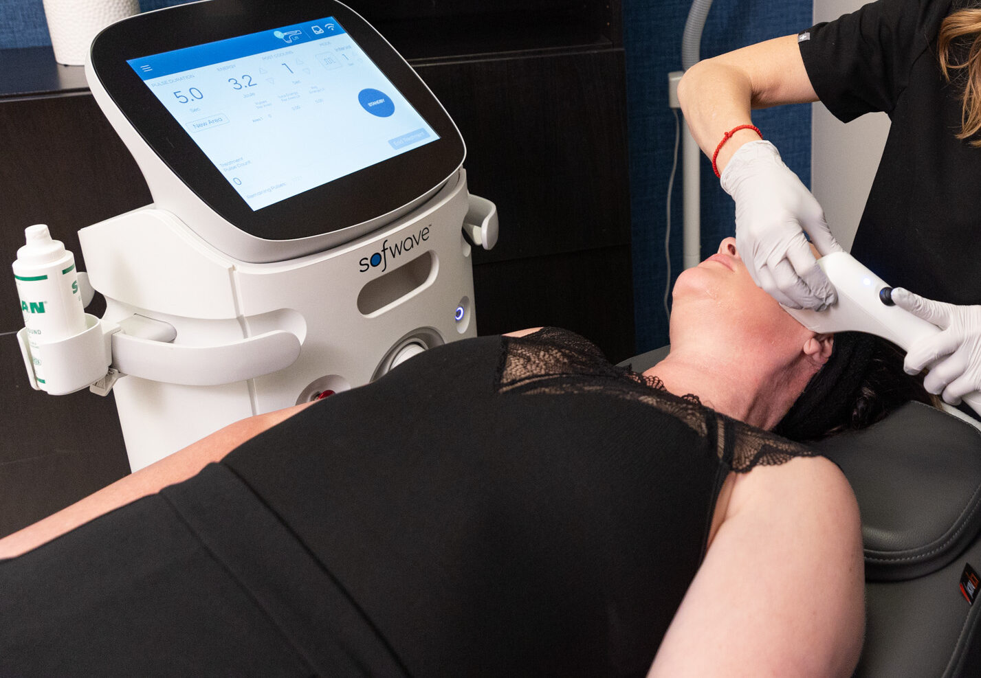 A patient lies on her back as she undergoes her Sofwave treatment, her provider guiding the hand-held device over her cheek. Sofwave is one of our most popular choices for skin rejuvenation in Southlake, TX, offering a non-invasive solution for skin tightening.