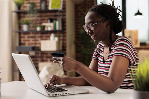 Woman holding credit card, making order in internet store