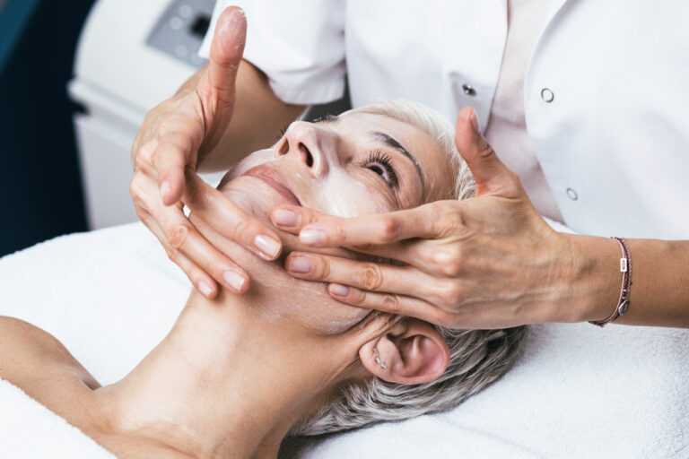An aesthetician applying a Melanage® Peel to a patient's skin